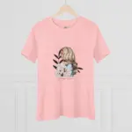 Light pink short-sleeve crew neck t-shirt displayed on a wooden hanger against a white paneled wall, featuring a centered graphic illustration of a woman with long blonde wavy hair viewed from behind, adorned with white hydrangea flowers and black decorative leaves, with 'Always Down' script text beneath the design